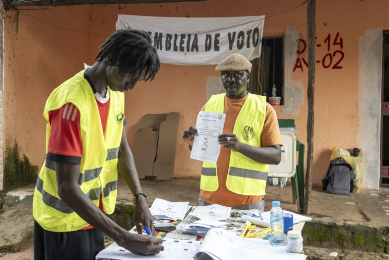 Un responsable de la Commission électorale nationale (CNE) montre un bulletin de vote dans un bureau de vote à Bissau, le 30 août 2026, après le vote de la Guinée-Bissau au référendum constitutionnel ( AFP / Samba BALDE )