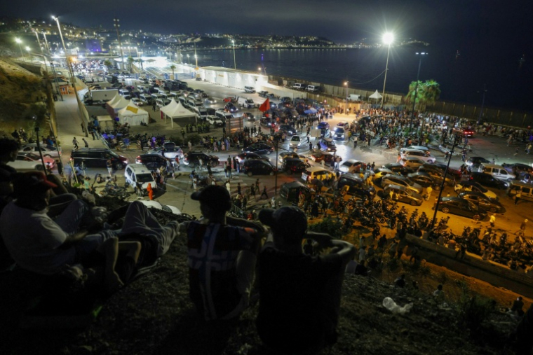 Des migrants se rassemblent à Bab Sebta, à la frontière entre le Maroc et l'enclave espagnole de Ceuta, le soir du 30 juillet 2026 ( AFP / Abdelmajid BZIOUAT )