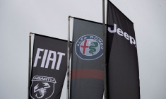 Des bannières montrant les logos de Fiat, Jeep, Abarth et Alfa Romeo sont suspendues à l'extérieur d'une concession automobile