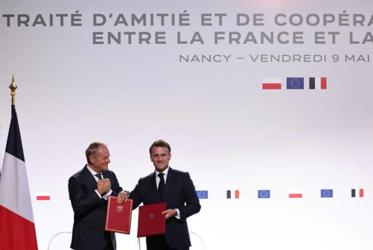 Le président français Emmanuel Macron (à droite) et le Premier ministre polonais Donald Tusk lors de la signature du traité d'amitié et de coopération entre leurs pays, le 9 mai 2025 à Nancy, dans l'est de la France ( POOL / Christophe PETIT TESSON )