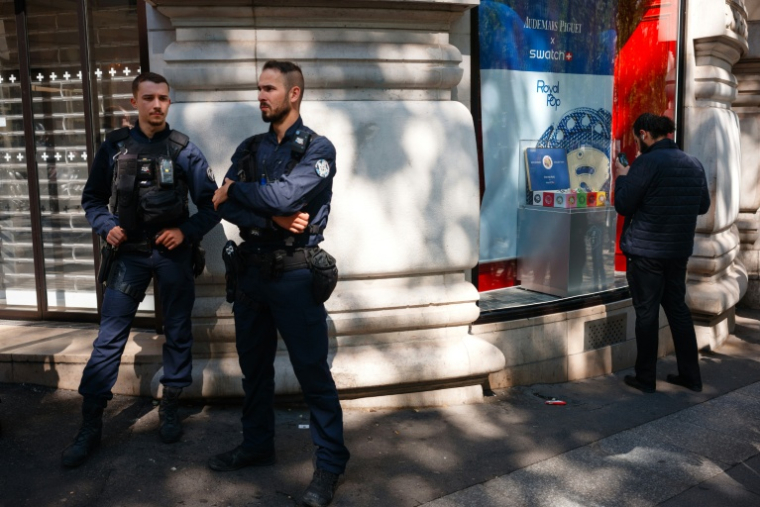 Des policiers montent la garde devant un magasin Swatch fermé lors du lancement de la montre Audemars Piguet Swatch "Royal Pop", le 16 mai 2026 à Paris ( AFP / Dimitar DILKOFF )