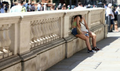 Des personnes se protégent du soleil derrière un mur, le 24 juin 2026 à Londres ( AFP / Toby Shepheard )