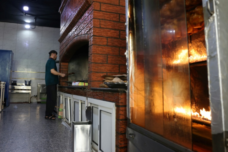 Un employé travaille devant un gril dans un restaurant de Ryad, le 14 août 2025, pendant la chaleur estivale accablante ( AFP / Fayez Nureldine )