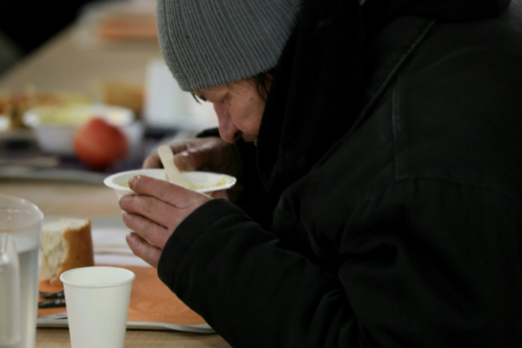 Une sans-abri profite d'un repas chaud offert par l'association "La Mie de Pain" à Paris, le 29 décembre 2025 ( AFP / Alain JOCARD )