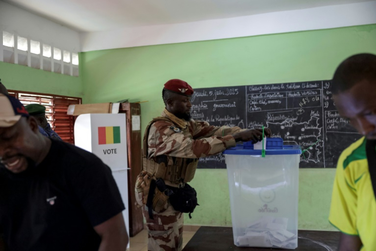Un soldat guinéen dépose son bulletin dans une urne d'un bureau de vote dans une école de Conakry, le 21 septembre 2025, lors d'un référendum constitutionnel en Guinée. ( AFP / Patrick MEINHARDT )