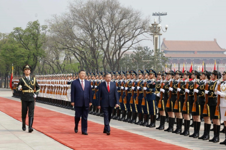 Photo prise et diffusée par l'Agence de presse vietnamienne (VNA), le 15 avril 2026, montrant le président chinois Xi Jinping (c) et le président vietnamien To Lam (d) inspectant la garde d'honneur au Palais de l'Assemblée du Peuple à Pékin ( Vietnam News Agency / - )