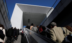 Des passants se promènent sur l'esplanade de La Défense, dans le quartier financier et d'affaires de La Défense, à l'ouest de Paris