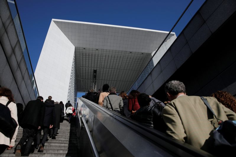 Des passants se promènent sur l'esplanade de La Défense, dans le quartier financier et d'affaires de La Défense, à l'ouest de Paris