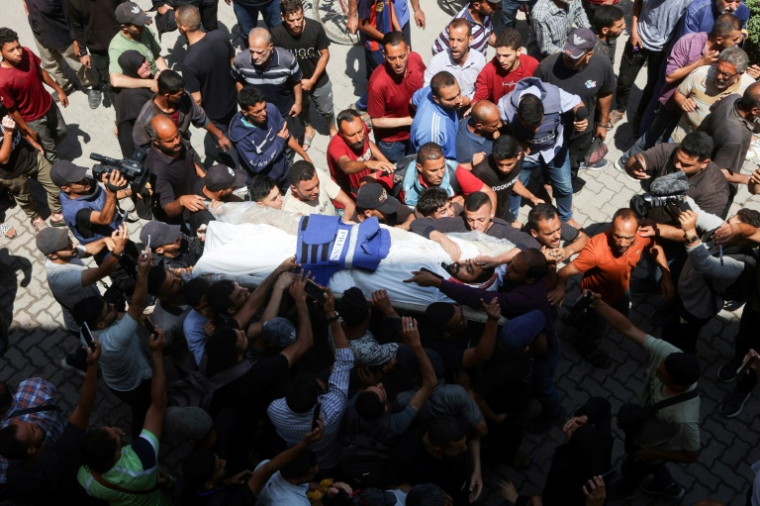 Des proches et collègues autour de la dépouille d'un de trois journalistes palestiniens tués par des frappes israéliennes, à l'hôpital Ahli Arab de Gaza-ville le 5 juin 2025 ( AFP / Omar AL-QATTAA )