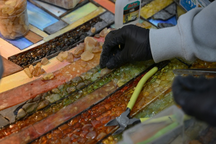 Une employée du groupe Amber Galbine travaillant l'ambre pour en faire des bijoux et des souvenirs à vendre, dans la région ukrainienne de Rivné, le 10 mai 2026 ( AFP / Genya SAVILOV )
