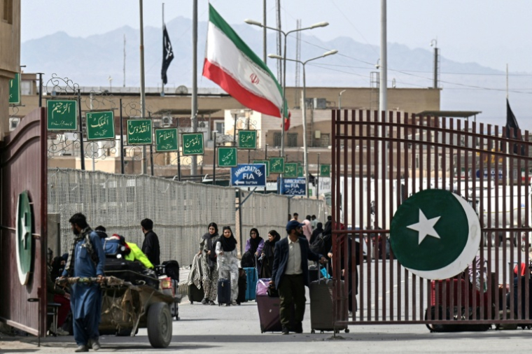 Des ressortissants pakistanais traversent la frontière de Taftan, au Pakistan, après leur retour d’Iran, le 2 mars 2026, sur fond de frappes américaines et israéliennes en cours contre l’Iran ( AFP / Banaras KHAN )