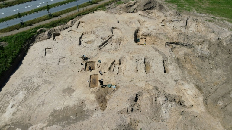 Vue aérienne d'archéologues travaillant sur un site funéraire de l'ère viking à Lisbjerg, au nord d'Aarhus, le 13 juin 2025 au Danemark ( AFP / James Brooks )
