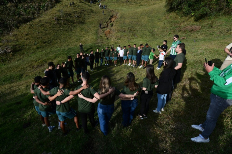 Les joueurs et les dirigeants de Chapecoense prient devant le mémorial dédié à l'accident d'avion du club brésilien, à la veille du dixième anniversaire de la catastrophe survenue au Cerro Gordo, près de La Unión, dans le département d'Antioquia, en Colombie, le 25 septembre 2026 ( AFP / Jaime SALDARRIAGA )