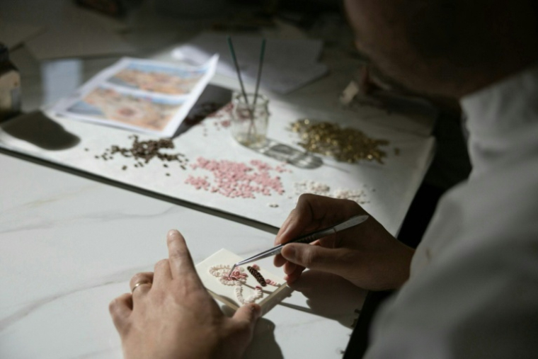 Le chef pâtissier français Bastien Blanc-Tailleur crée des décoration pour un gâteau de mariage dans son atelier de Saint-Rémy-lès-Chevreuse, dans les Yvelines, le 10 avril 2026 ( AFP / Thomas SAMSON )