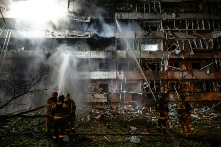 Des pompiers sur le site d'une frappe de missile russe contre un immeuble résidentiel à Kiev, le 14 octobre 2026 en Ukraine ( AFP / Genya SAVILOV )
