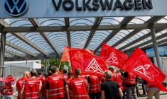 Des salariés de Volkswaggen, portant des drapeaux d'IG Metall, protestant contre le plan de restructuration préparé par la direction, à Zwickau, le 9 juillet 2026 ( AFP / Jens SCHLÜTER )