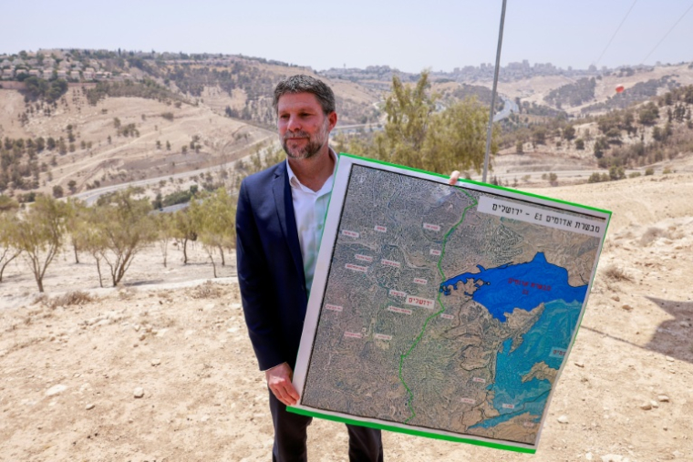 Le ministre israélien des Finances Bezalel Smotrich tient une carte à l'extérieur de Jérusalem, en Cisjordanie occupée, le 14 août 2025 ( AFP / Menahem Kahana )