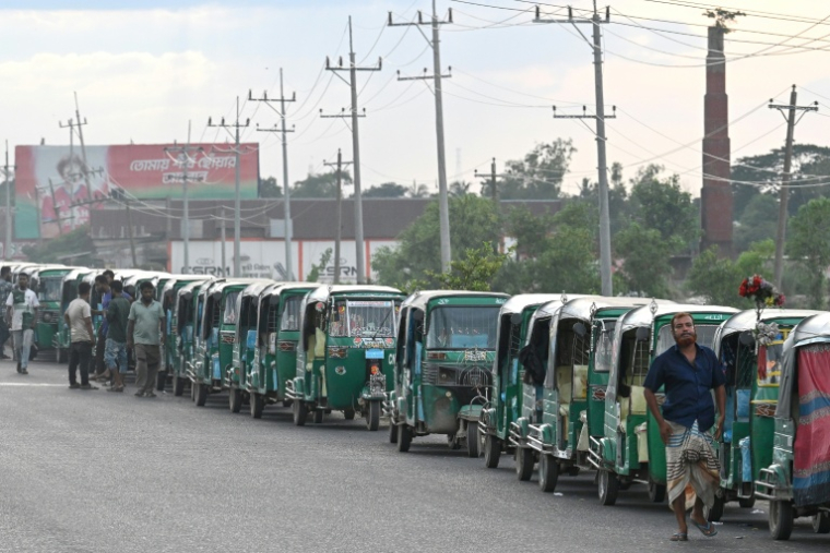 Des rickshaws fonctionnant au gaz naturel comprimé attendent de pouvoir faire un plein, le 12 août 2026 à Brahmanbaria, dans l'est du Bangladesh  ( AFP / Salahuddin Ahmed )