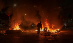 Un homme jette un pneu dans un feu lors d'affrontements avec la police, alors que des manifestants protestent contre les résultats préliminaires du second tour de l'élection présidentielle à Bogotá, en Colombie, le 21 juin 2026 ( AFP / Diego Cuevas )