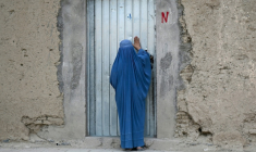 Une Afghane en burqa frappe à la porte d'une maison, à Kandahar, en Afghanistan, le 28 septembre 2026 ( AFP / Sanaullah SEIAM )