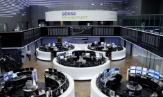 Des traders travaillent devant le tableau de l'indice boursier allemand DAX, à la bourse de Francfort