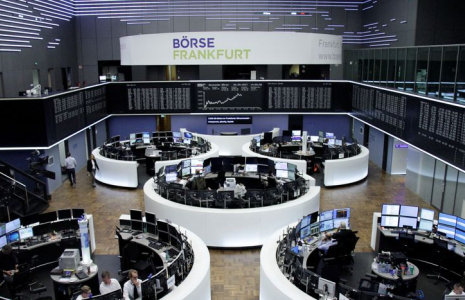 Des traders travaillent devant le tableau de l'indice boursier allemand DAX, à la bourse de Francfort