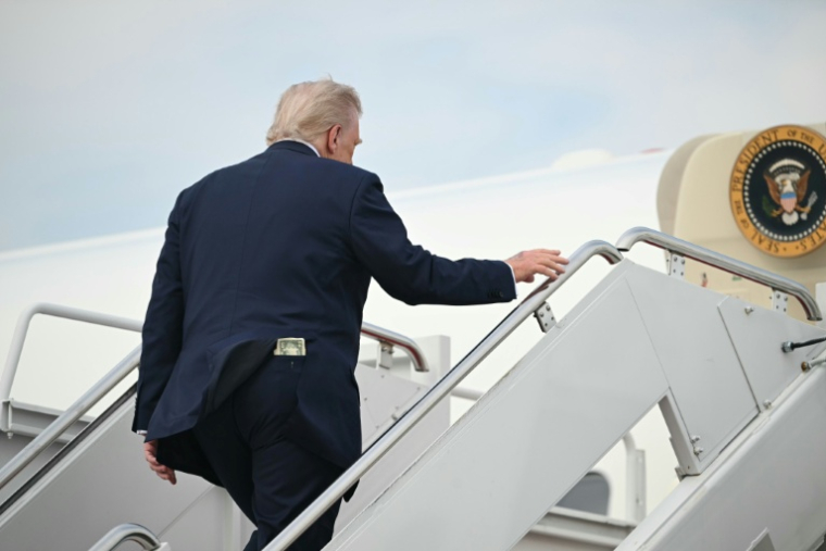 Donald Trump avec un billet de 50 dollars dans sa poche arrière, près de Washington en mai 2025 ( AFP / SAUL LOEB )