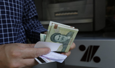 Un homme tenant des rials à Téhéran, en Iran. ( AFP / ATTA KENARE )