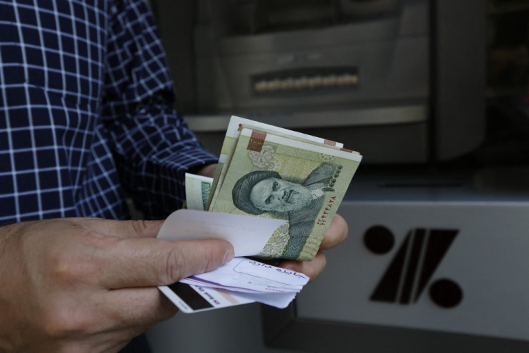 Un homme tenant des rials à Téhéran, en Iran. ( AFP / ATTA KENARE )