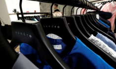 Des vêtements pour femmes sur des cintres à l'intérieur d'un magasin de vêtements de luxe Sandro, exploité par le groupe SMCP