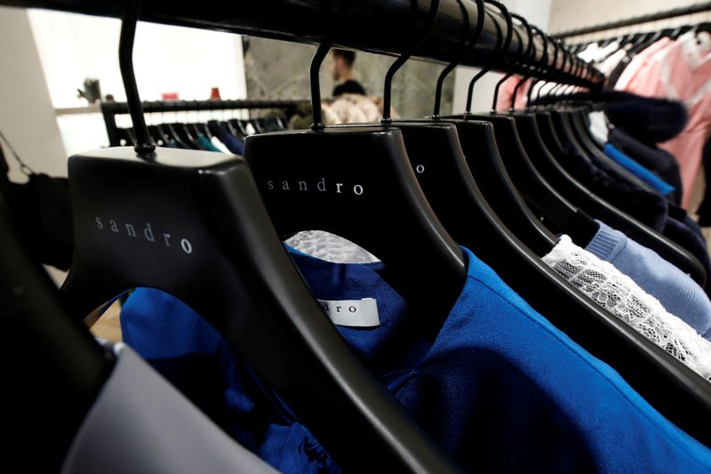 Des vêtements pour femmes sur des cintres à l'intérieur d'un magasin de vêtements de luxe Sandro, exploité par le groupe SMCP