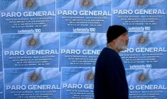 Un homme passe devant des affiches appelant à la grève générale le 9 mai 2024 à Buenos Aires, la deuxième depuis le début du mandat du président argentin Javier Milei ( AFP / Luis ROBAYO )