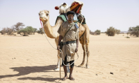 Sidnq, un membre de l'unité du Groupement nomade de la Garde nationale mauritanienne, pose pour un portrait à côté de son dromadaire dans la région de Hodh Ech Chargui (Mauritanie), le 7 avril 2025 ( AFP / PATRICK MEINHARDT )