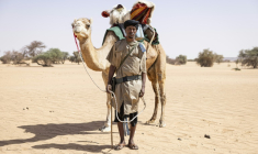 Sidnq, un membre de l'unité du Groupement nomade de la Garde nationale mauritanienne, pose pour un portrait à côté de son dromadaire dans la région de Hodh Ech Chargui (Mauritanie), le 7 avril 2025 ( AFP / PATRICK MEINHARDT )