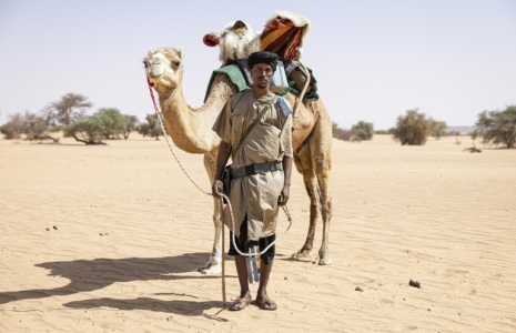 Sidnq, un membre de l'unité du Groupement nomade de la Garde nationale mauritanienne, pose pour un portrait à côté de son dromadaire dans la région de Hodh Ech Chargui (Mauritanie), le 7 avril 2025 ( AFP / PATRICK MEINHARDT )