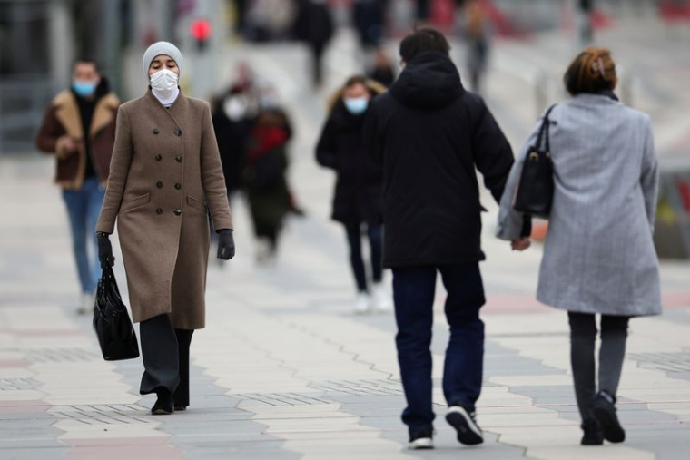 Des personnes marchent dans le quartier financier de La Défense