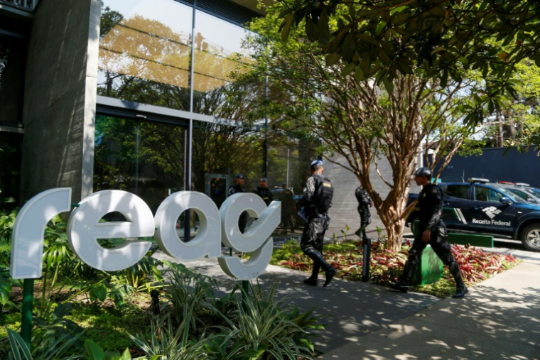 Des policiers devant un bâtiment de REAG Investments pendant une opération contre un réseau de blanchiment d'argent, à Sao Paulo, au Brésil, le 28 août 2025 ( AFP / Miguel SCHINCARIOL )