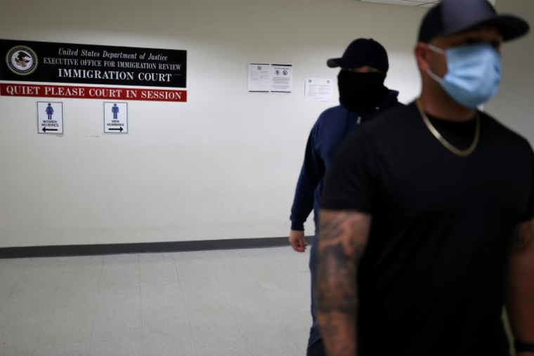 Des officiers en civil de la police fédérale de l'immigration (ICE) attendent dans un couloir d'un tribunal fédéral de l'immigration à New York le 6 juin 2025. ( AFP / CHARLY TRIBALLEAU )