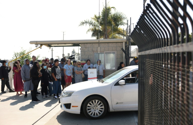 Des proches d'ouvriers agricoles arrêtés par la police de l'immigration font la queue pour récupérer leurs affaires, devant une ferme de Camarillo, en Californie, le 11 juillet 2025 ( AFP / Patrick T. Fallon )