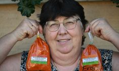 La cultivatrice Rozsa Benyi pose avec deux sachets de paprika devant son domicile à Homokmegy, dans le sud de la Hongrie, le 19 septembre 2026  ( AFP / Attila KISBENEDEK )