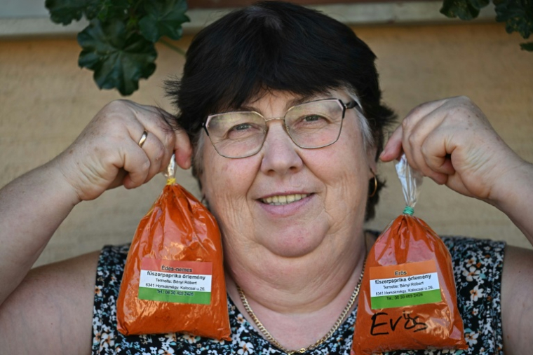 La cultivatrice Rozsa Benyi pose avec deux sachets de paprika devant son domicile à Homokmegy, dans le sud de la Hongrie, le 19 septembre 2026  ( AFP / Attila KISBENEDEK )