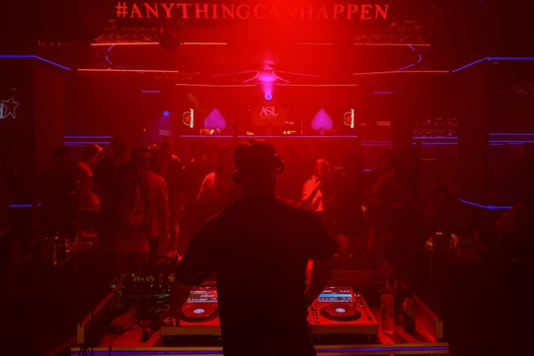 Cette photo prise le 16 avril 2026 montre des gens en train de danser autour d'un DJ qui se produit dans une discothèque de Rangoun.  ( AFP / Sai Aung MAIN )