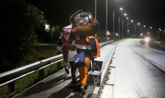 Des étrangers portant leurs affaires marchent dans une rue de Stanford, à environ 120 km du Cap (Afrique du Sud), le 2 juin 2026, après avoir été menacés par des groupes anti-migrants. ( AFP / RODGER BOSCH )