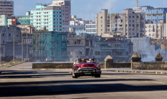 Des touristes circulent dans une vieille voiture américaine utilisée comme taxi sur le Malecon, l'avenue de bord de mer de La Havane, peu fréquentée en raison d'une pénurie de combustible, le 8 février 2026 ( AFP / ADALBERTO ROQUE )
