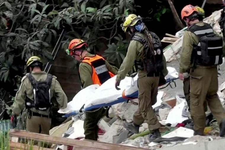 Image tirée d'une vidéo d'AFPTV montrant des équipes de secours sortant les corps de victimes des décombres d'un immeuble résidentiel détruit par une attaque de missile iranienne dans la ville de Haïfa, dans le nord d'Israël, le 6 avril 2026 ( AFPTV / Jorge NOVOMINSKY )