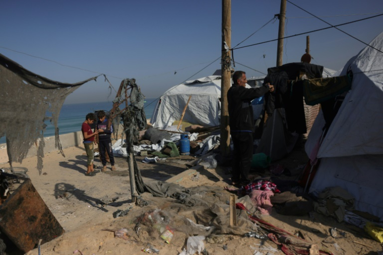 Des Palestiniens constatent les dégâts après une frappe israélienne sur un camp de déplacés dans la zone de Mawassi, à Khan Younès, dans le sud de la bande de Gaza, le 20 novembre 2025 ( AFP / Bashar Taleb )