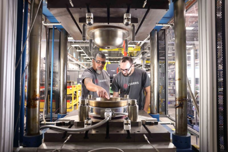 Deux employés de L3Harris inspectent l'outillage avant le moulage d'un composant dans l'usine de fabrication avancée de Huntsville