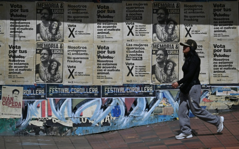 Un femme passe devant des affiches de campagne du président colombien et candidat à sa réélection Ivan Cepeda à Bogota le 15 juin 2026, en Colombie ( AFP / Juan BARRETO )