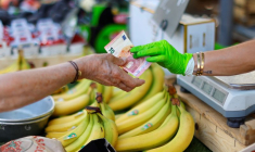 Une cliente paie avec un billet de dix euros dans un marché local à Nice
