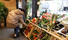 Une cliente achète des légumes à l'épicerie fine Andreas, à Londres